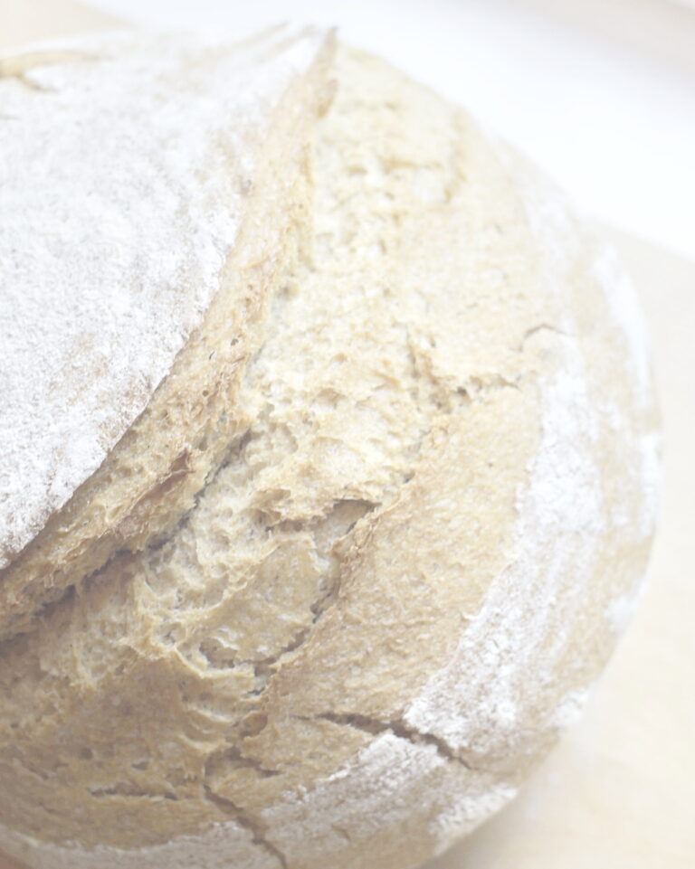close-up of a round artisan sourdough bread, highlighting the crispy crust