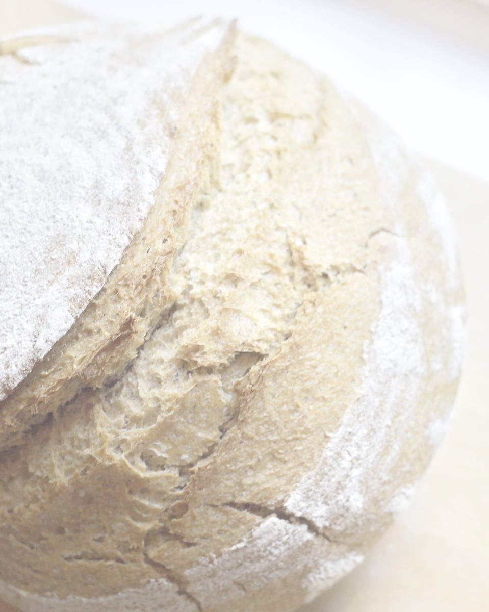 close-up of a round artisan sourdough bread, highlighting the crispy crust