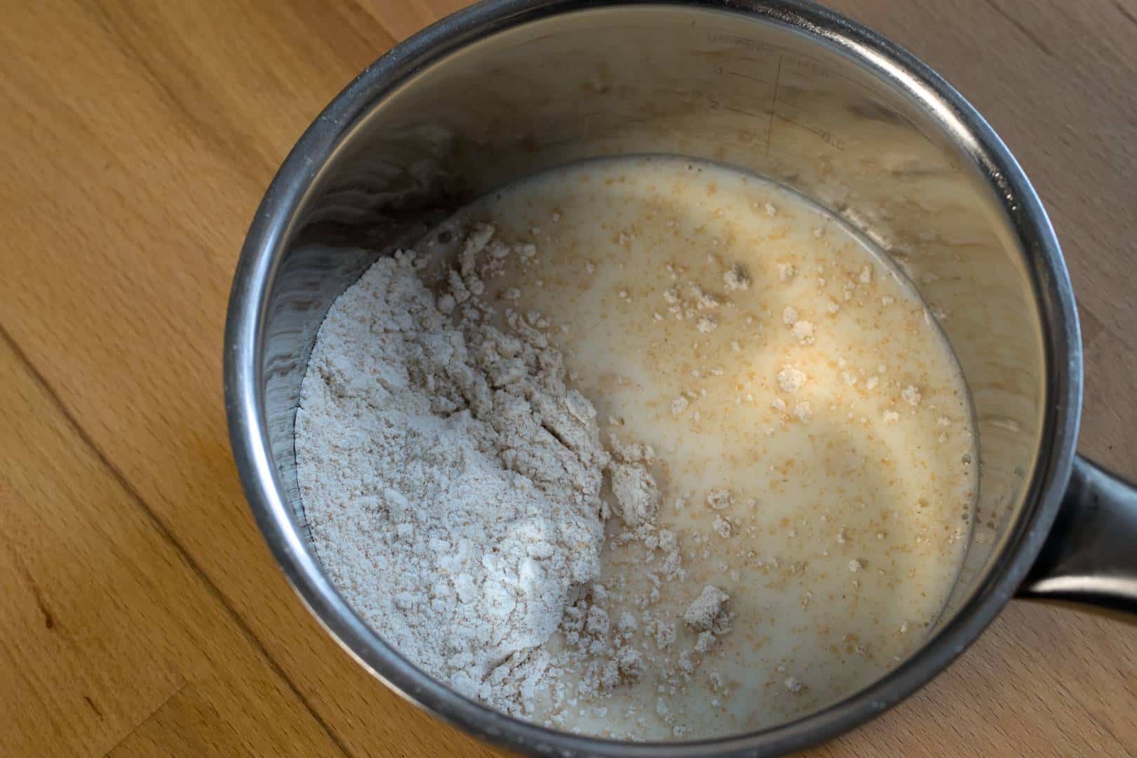 closeup of freshly milled flour and milk in a small saucepan