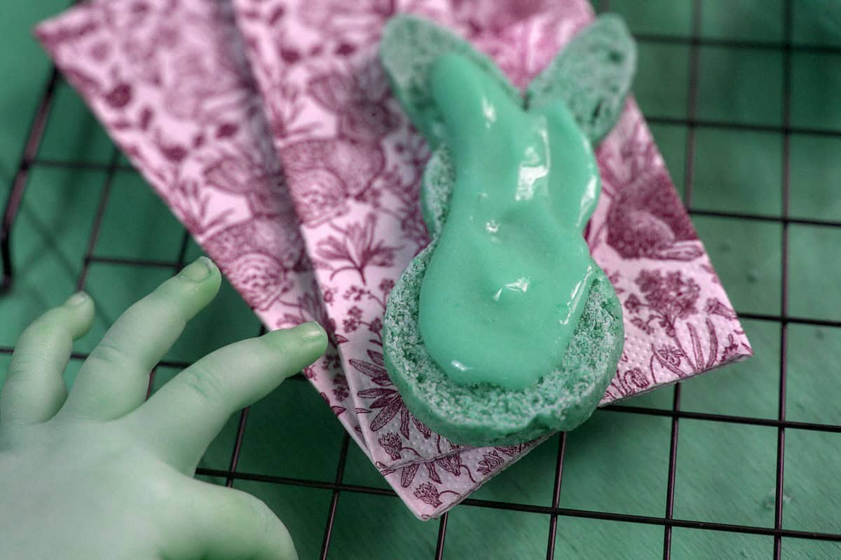 closeup of child's hand reaching for a sliced Spelt brioche bunny topped with fruit curd