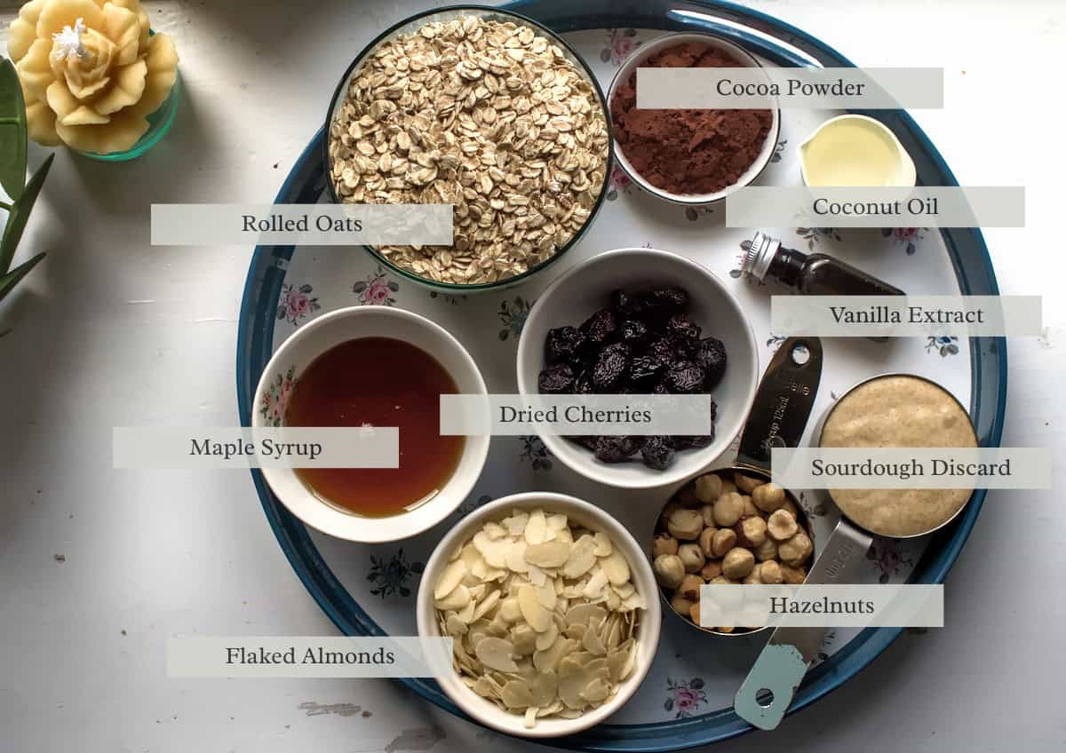 close up of Chocolate Cherry Sourdough Granola ingredients laid out on a round tray