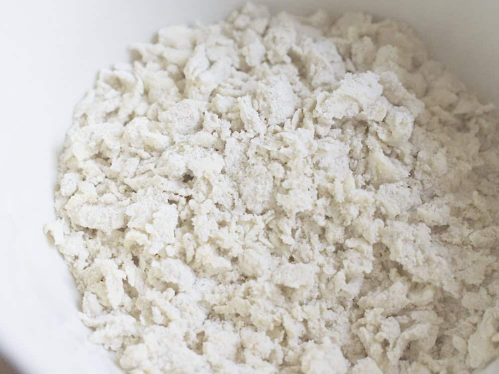 closeup of butter and flour mixture, showing the coarse crumbly texture and pea-sized chunks of butter