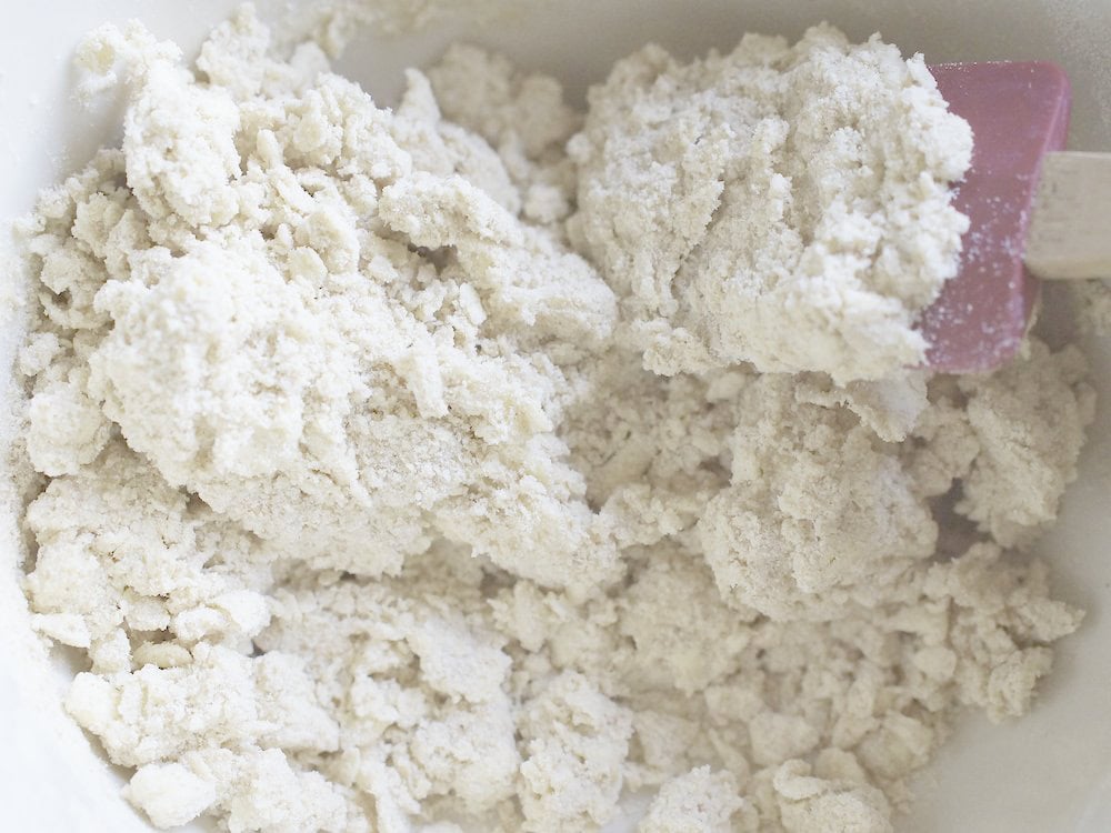 closeup of sourdough pie crust dough being stirred with a red silicone spatula