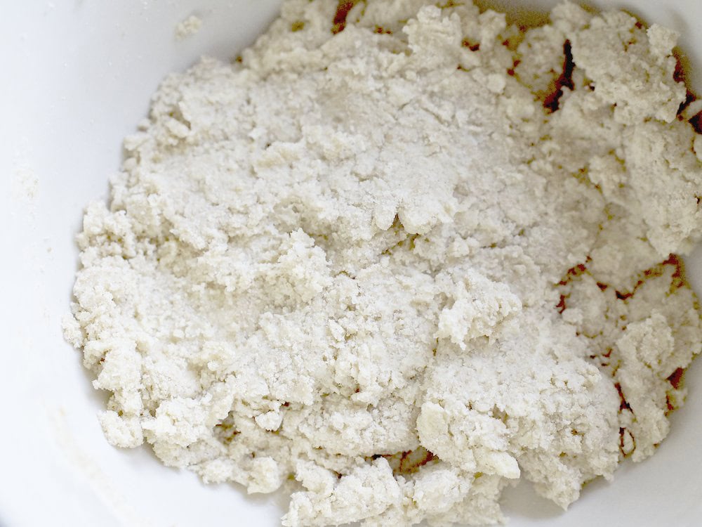 closeup of finished sourdough pie crust dough in a pale blue mixing bowl