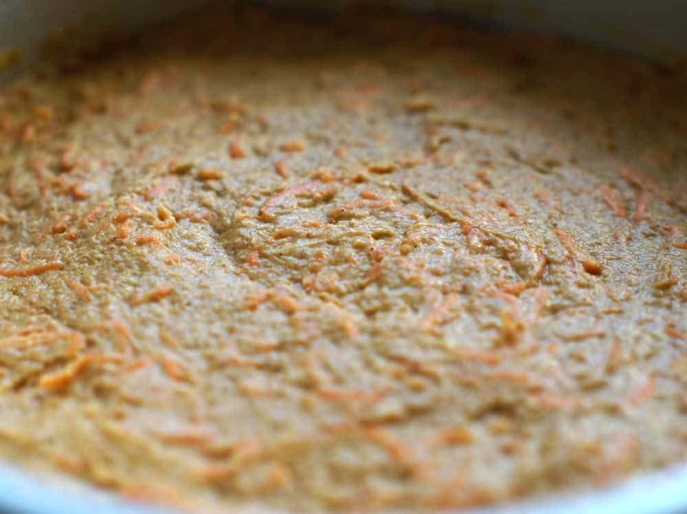 closeup of unbaked, carrot flecked batter in the cake pan