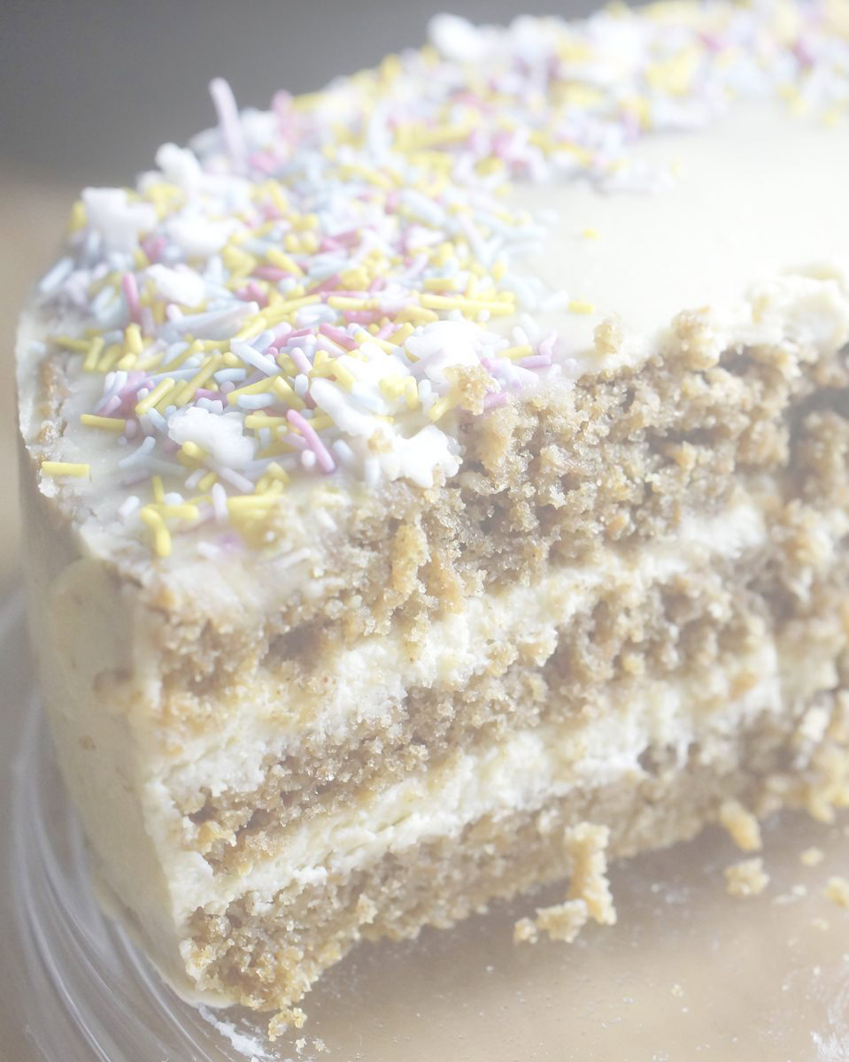 cut fresh milled spelt carrot cake decorated with maple cream cheese frosting and sprinkles
