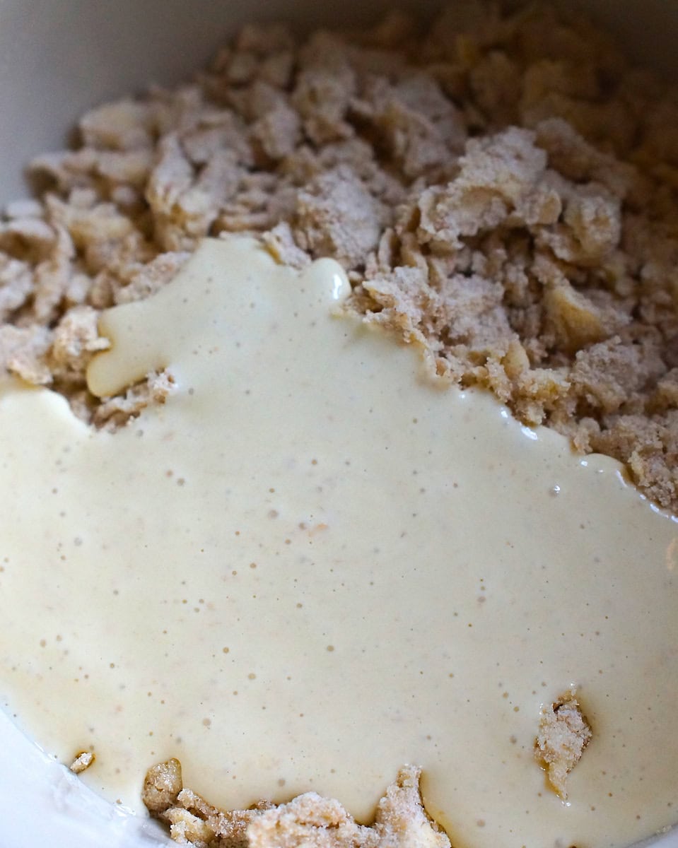 closeup of sourdough starter being poured on top of the butter and flour mixture