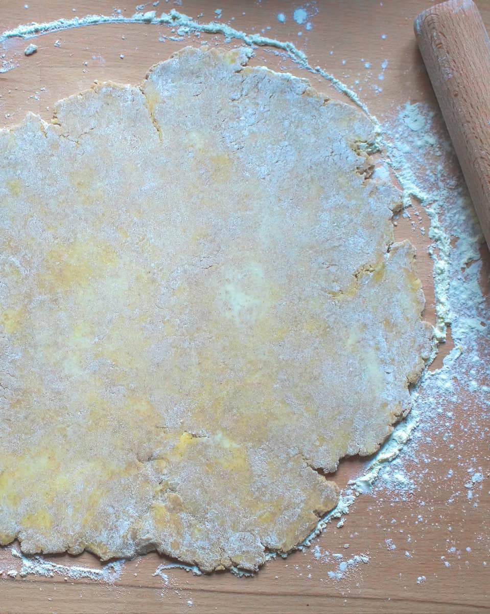 overhead view of sourdough pie crust rolled out an a well floured wooden countertop