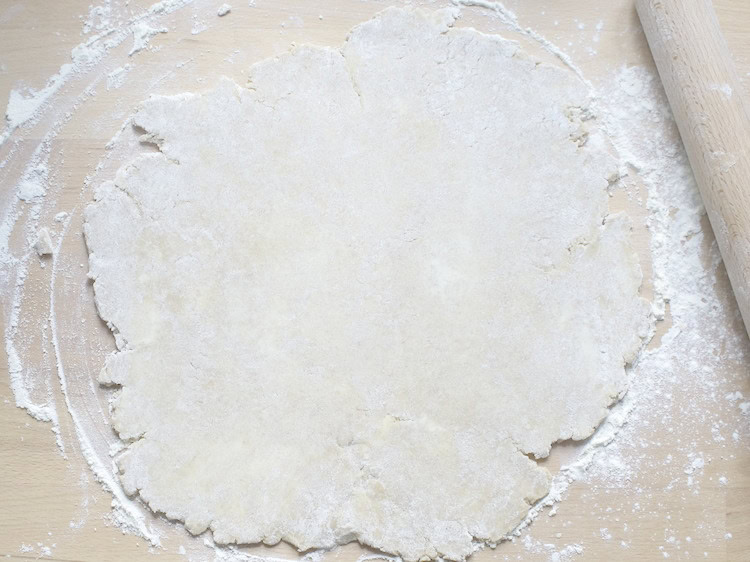 overhead view of sourdough pie crust rolled out an a well floured wooden countertop
