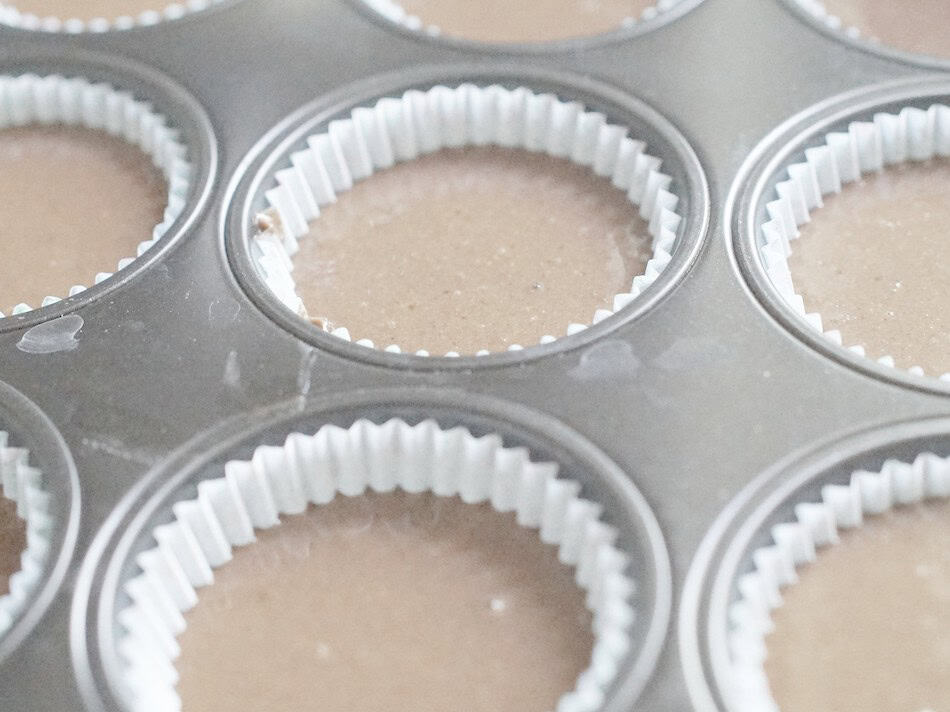 closeup of vegan chocolate cupcake batter in paper lined muffin try