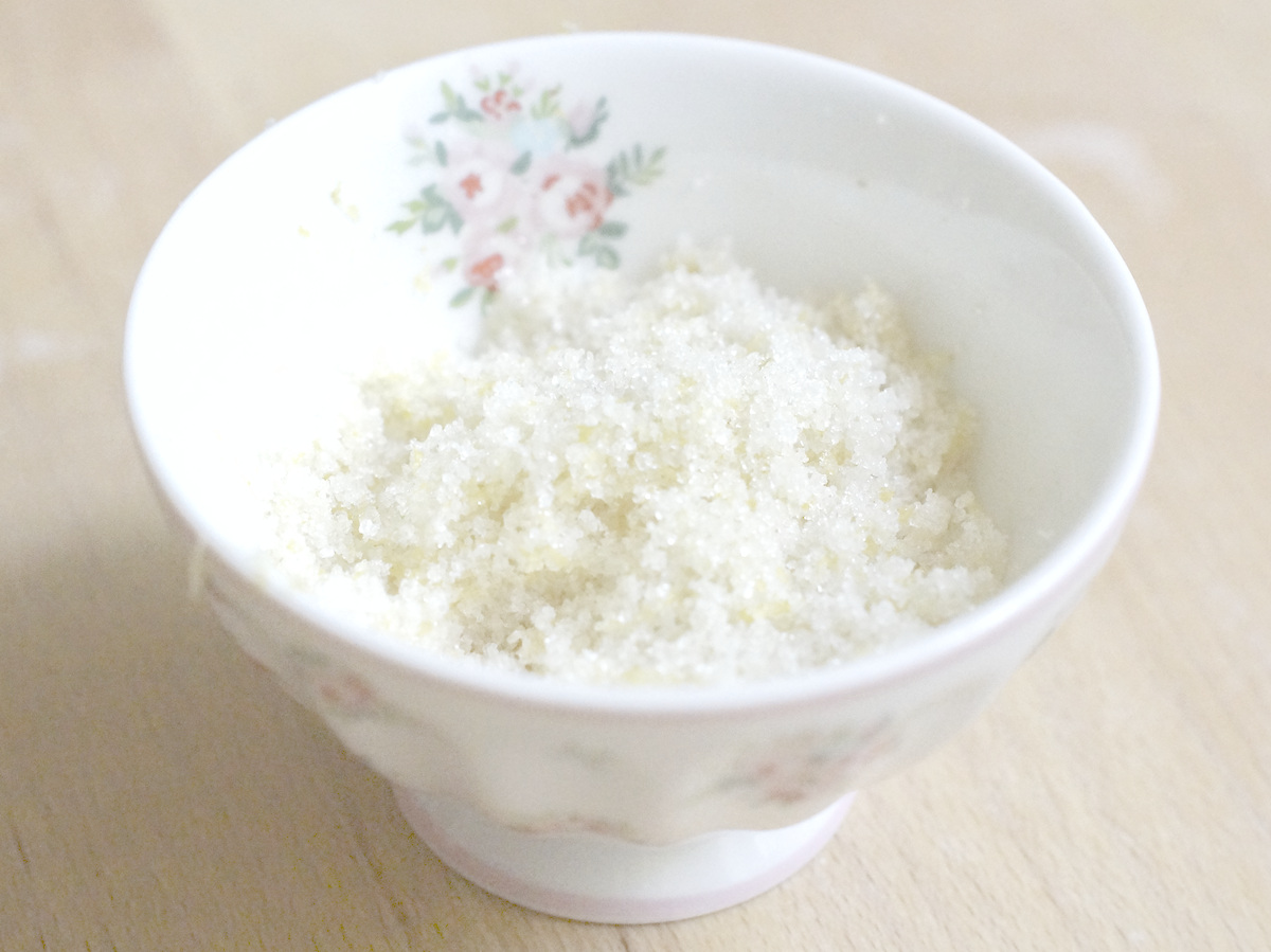 a small porcelain bowl with flowery decorations, filled with fresh lemon zest infused sugar