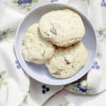 Sourdough discard chocolate chip cookies with melted chocolate chunks and golden brown edges served on a blue plate.