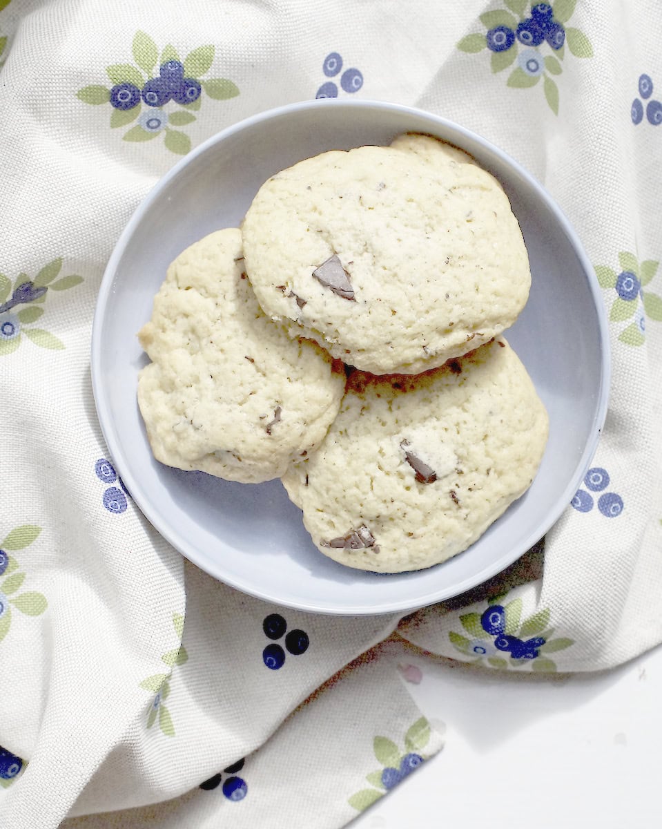 Sourdough discard chocolate chip cookies with melted chocolate chunks and golden brown edges served on a blue plate.