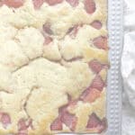 Close-up of fresh strawberry sourdough sheet cake baked in a rectangular pan, with jammy red berries nestled into a golden, vanilla-scented crumb.