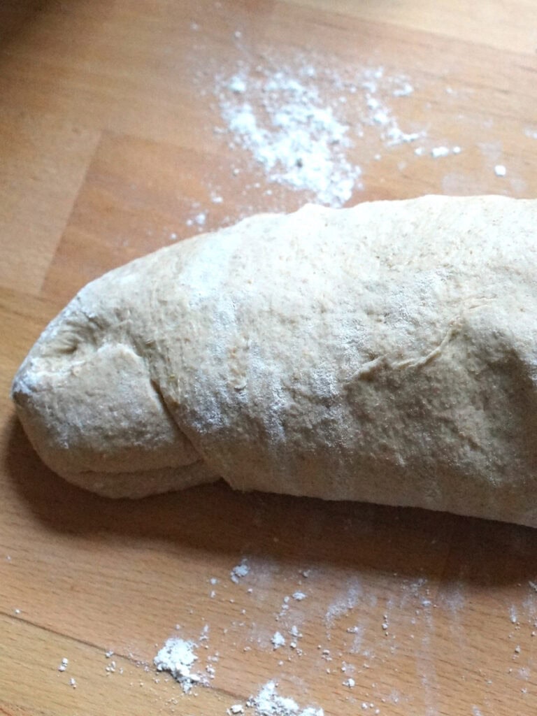 Kamut sourdough sandwich bread is folded and rolled into a loose log.