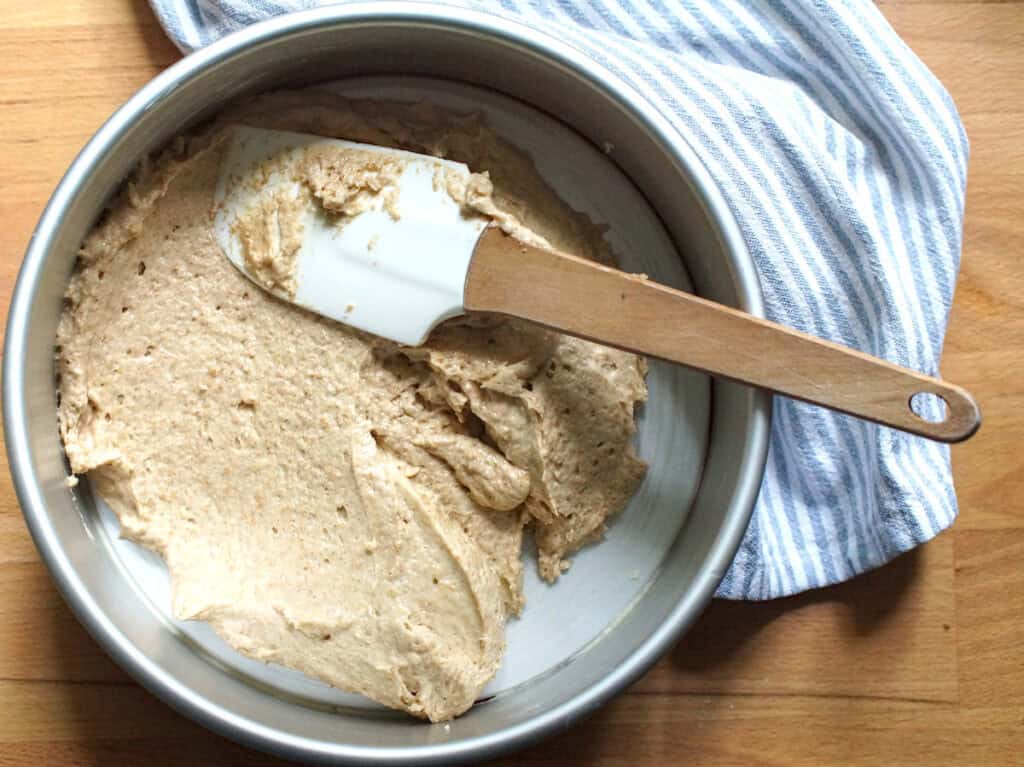 Overhead shot of the luscious cake batter being spread around in the cake pan.