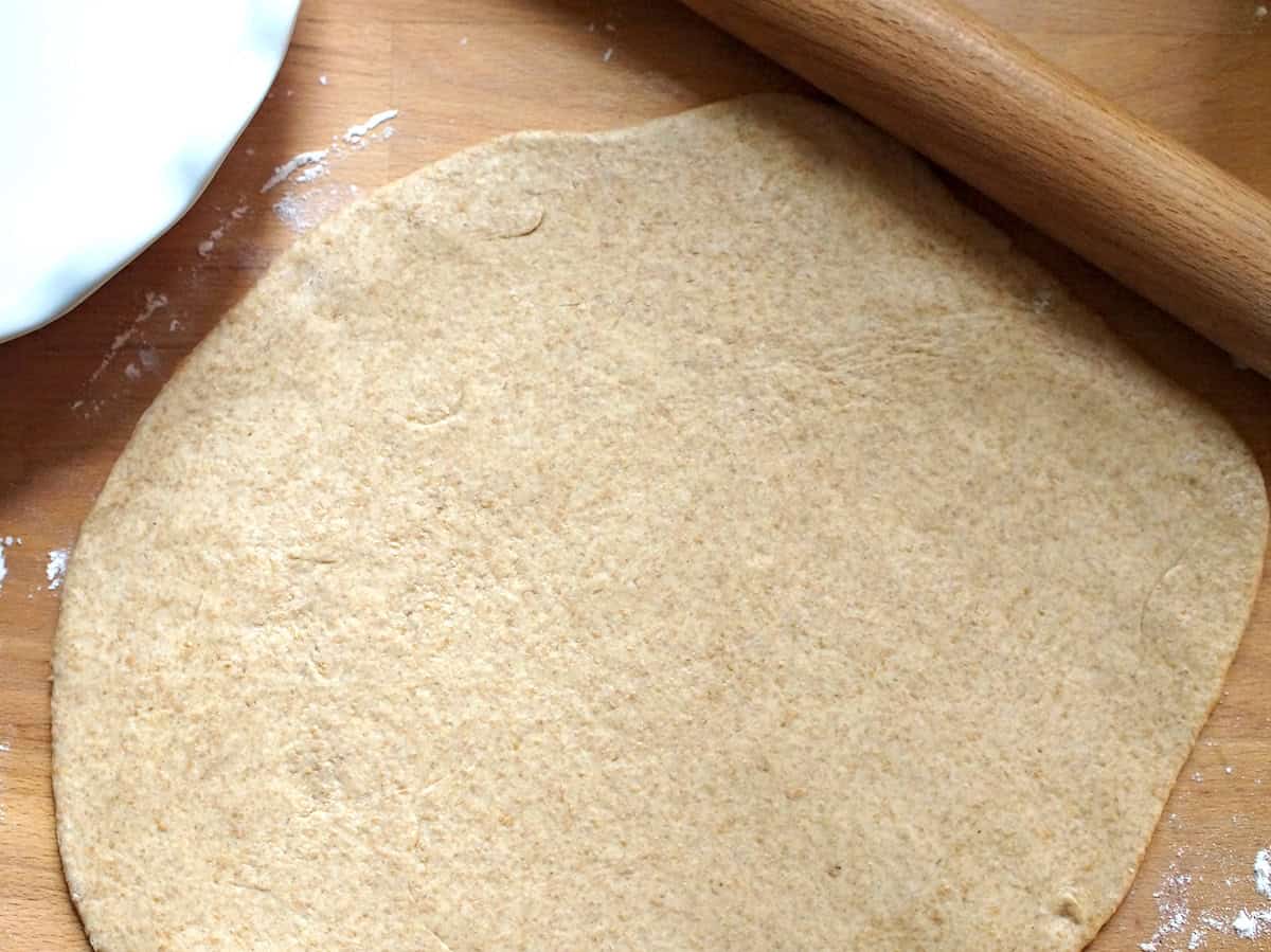 Soft, freshly milled wheat dough for German onion pie, rolled out on a wooden counter.