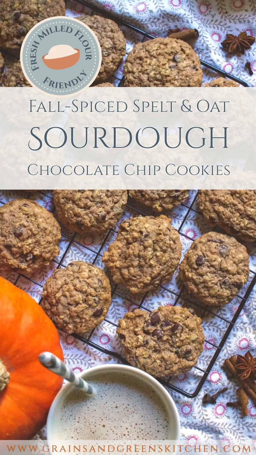 Fresh milled spelt sourdough chocolate chip cookies on a black wire rack sitting on a patterned tea towel. Whole fall spices are scattered on the side, next tu a bright orange pumpkin and a cup of frothy milk tea.