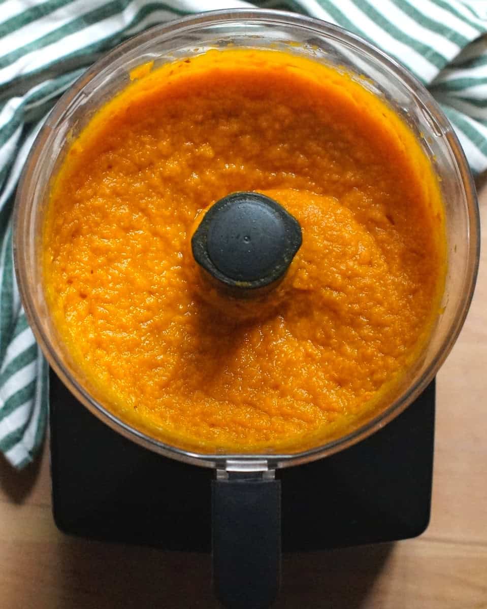 Bright orange pumpkin puree blended smooth in a food processor.