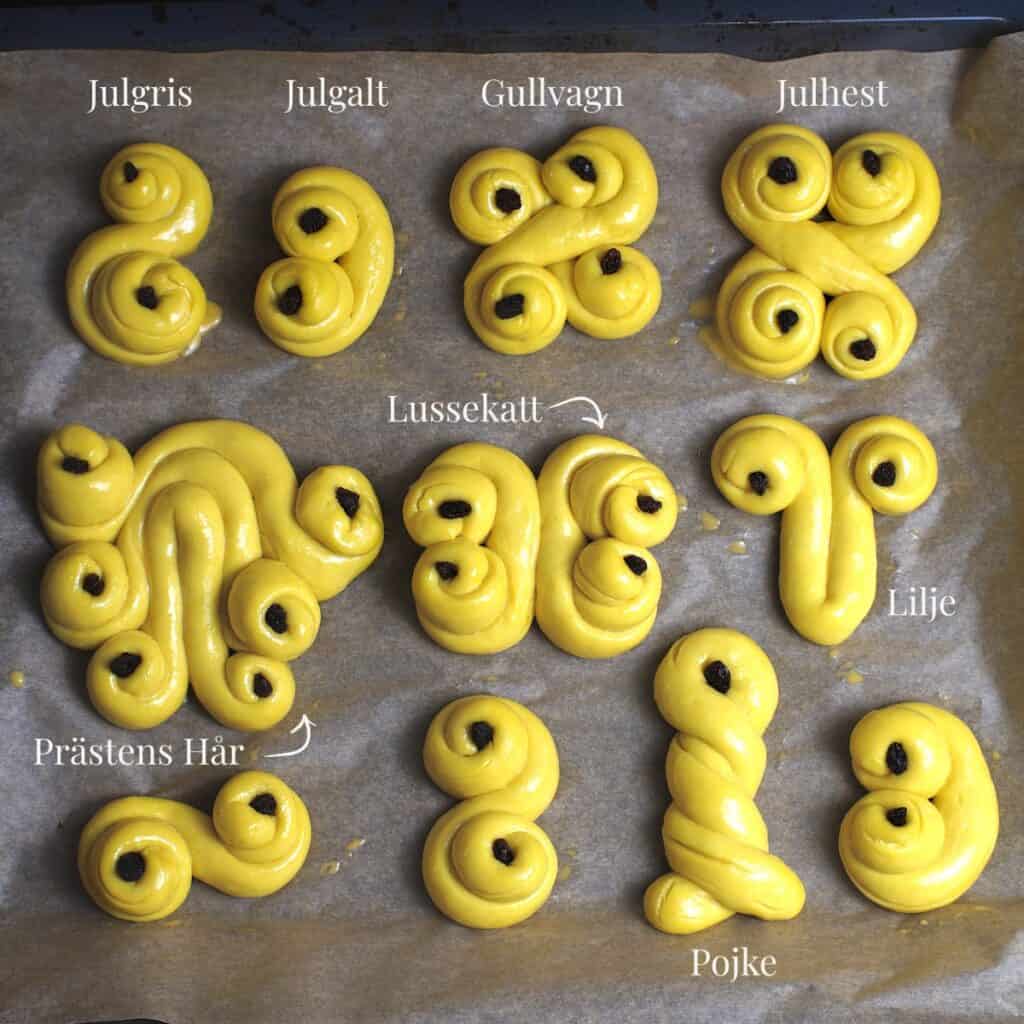 Overhead view of a tray of sourdough saffron buns or lussekatter, showing a variety of traditional shapes and their Swedish names.