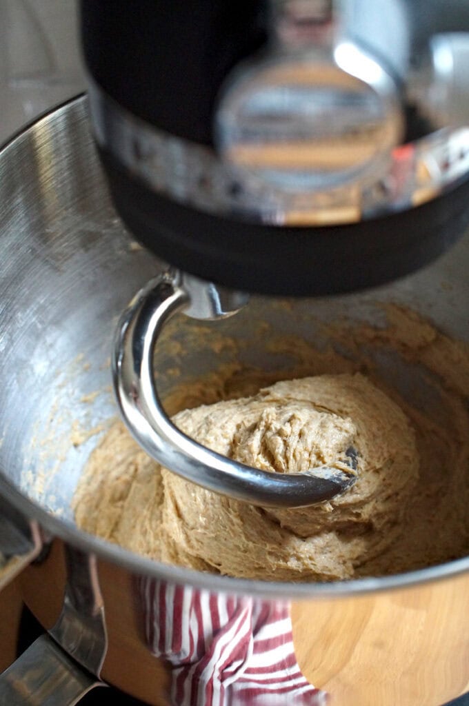 Sticky whole wheat sourdough sandwich bread dough made with fresh milled flour in a stand mixer bowl with dough hook.