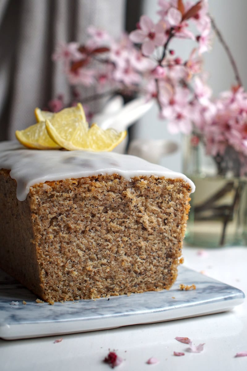 Close-up crumb shot of lemon poppy seed loaf made with fresh milled flour, showing even golden-brown crumb studded with poppy seeds