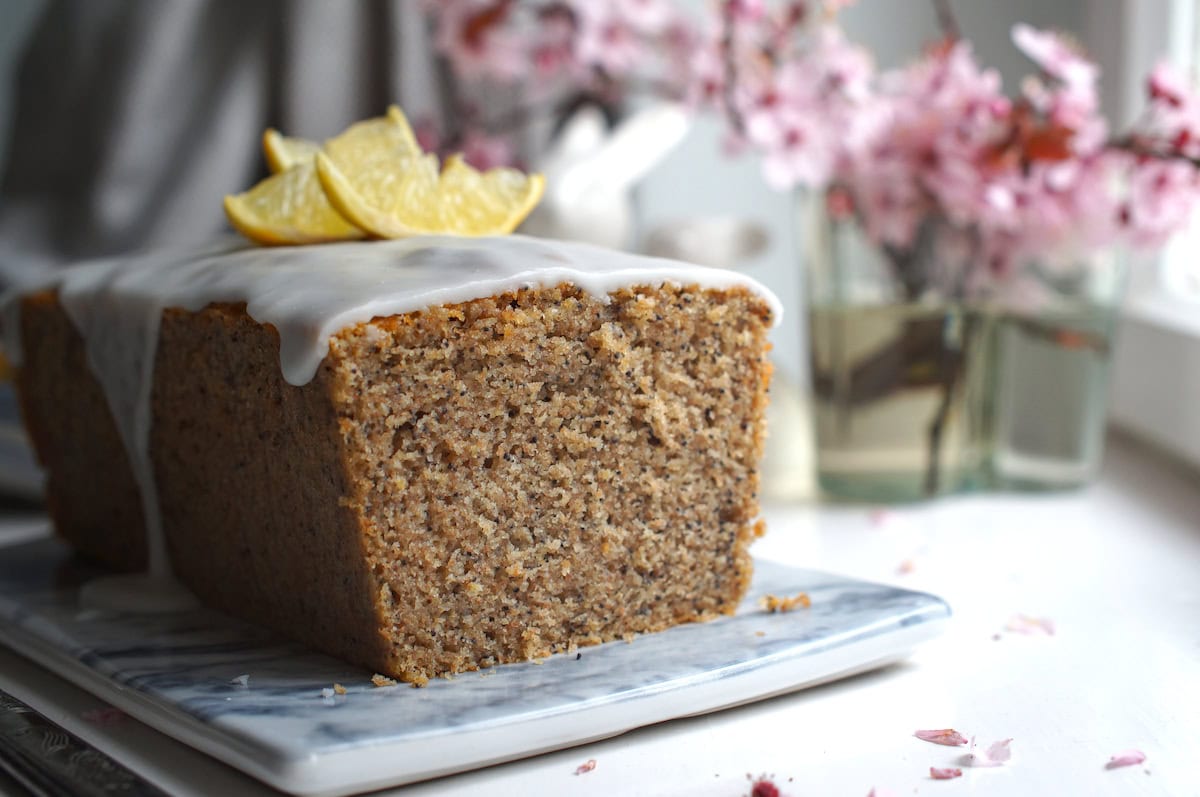 Close-up crumb shot of lemon poppy seed loaf made with fresh milled flour, showing even golden-brown crumb studded with poppy seeds